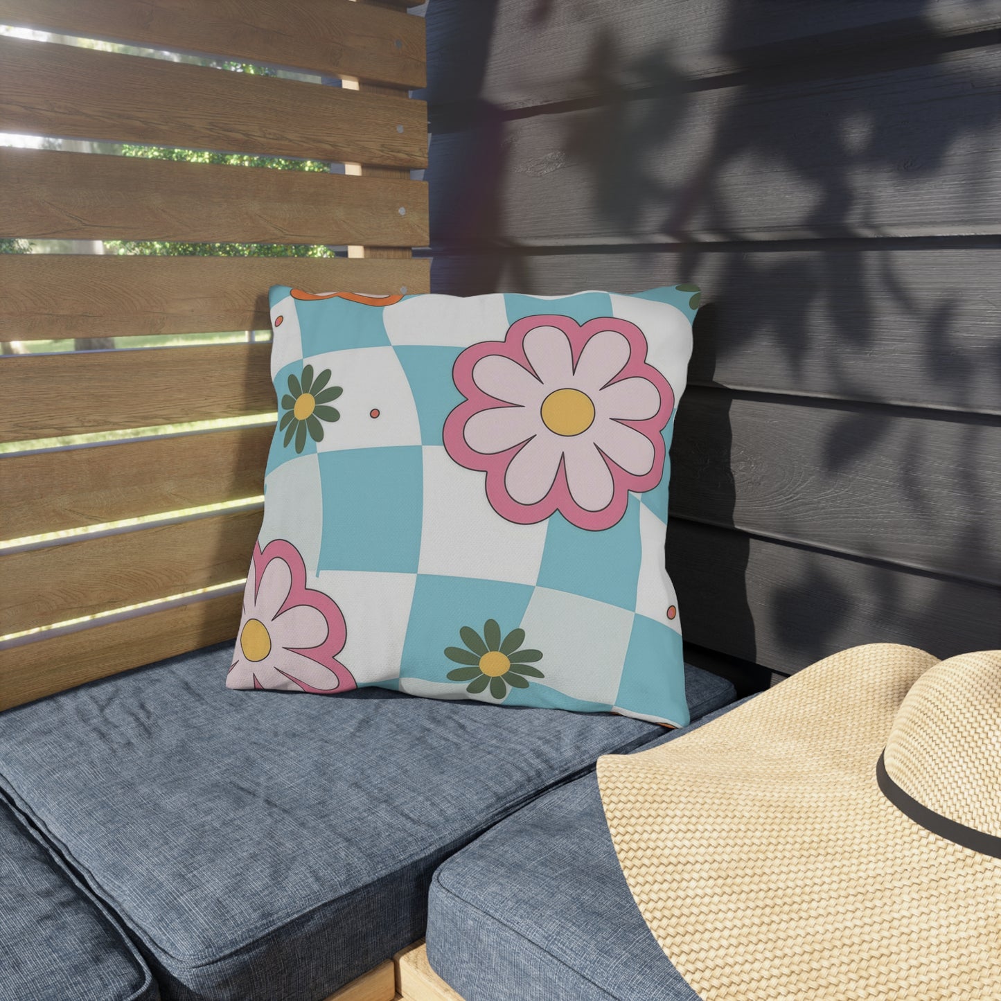 Durable outdoor pillow in blue, pink, and yellow tones against natural background