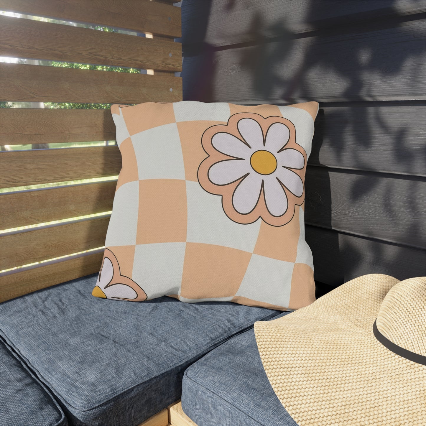 Sunshine daisy pillow styled on porch seating with greenery