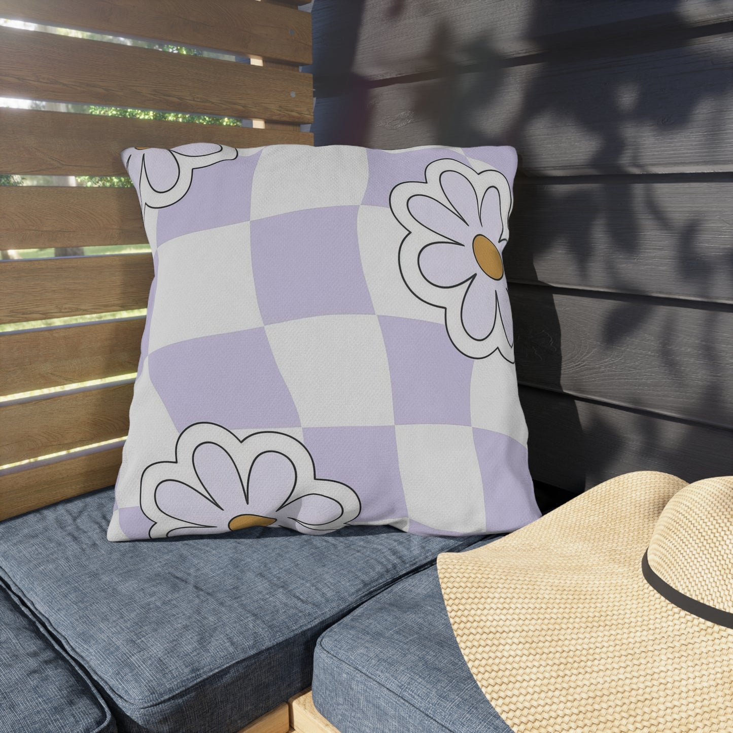 Close-up of lavender checkered outdoor pillow with floral design in purple and orange