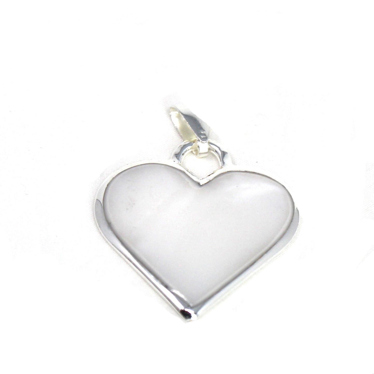 Corazón Blanco heart pendant resting on rustic wood background