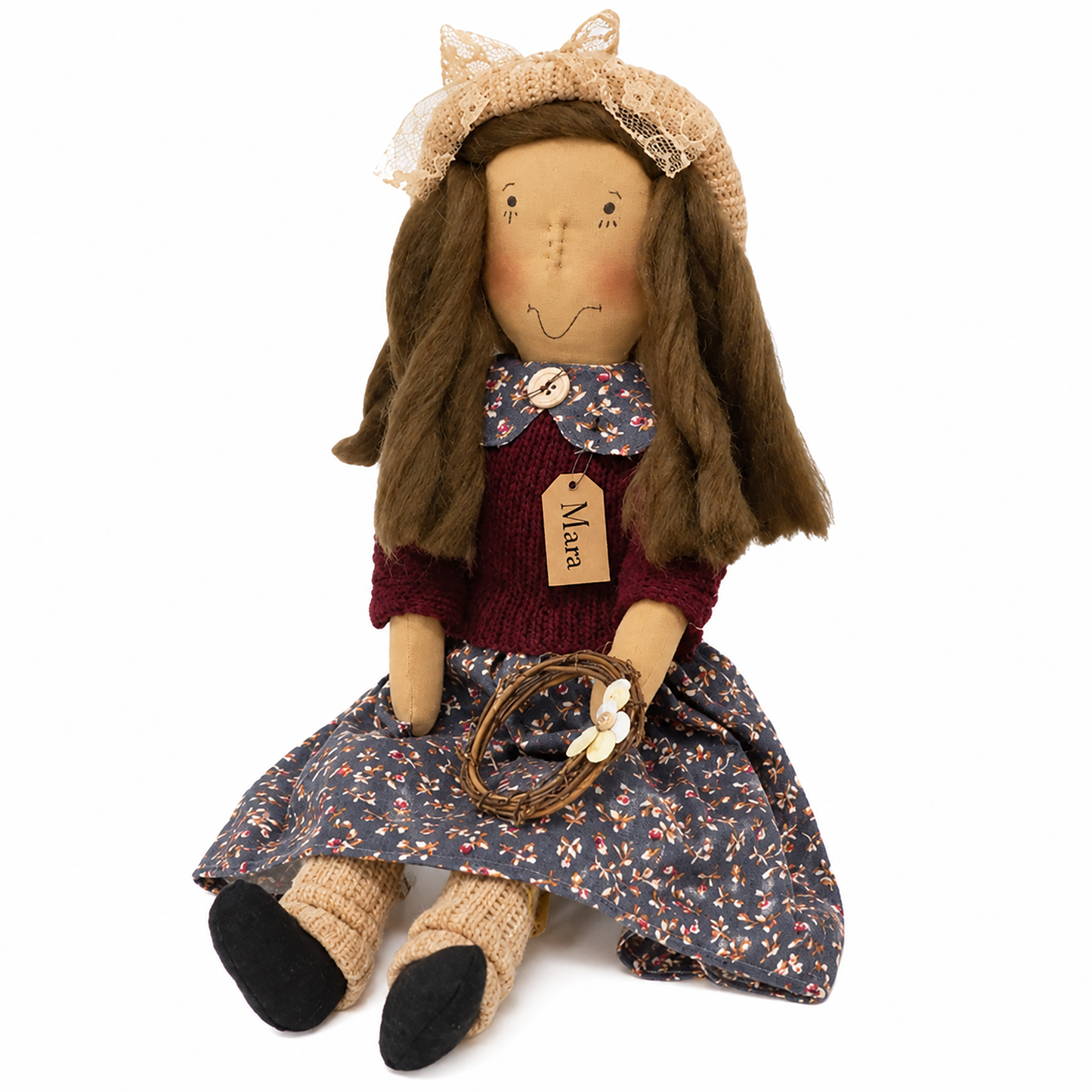 A rustic handmade rag doll named 'Mara' with long brown hair, wearing a floral blue dress, maroon knit top, lace-trimmed bonnet, and holding a small basket with white flowers, photographed on a white background.