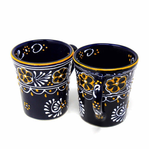 Pair of artisan-crafted ceramic mugs displayed on a wooden surface, highlighting their rustic yet elegant design.