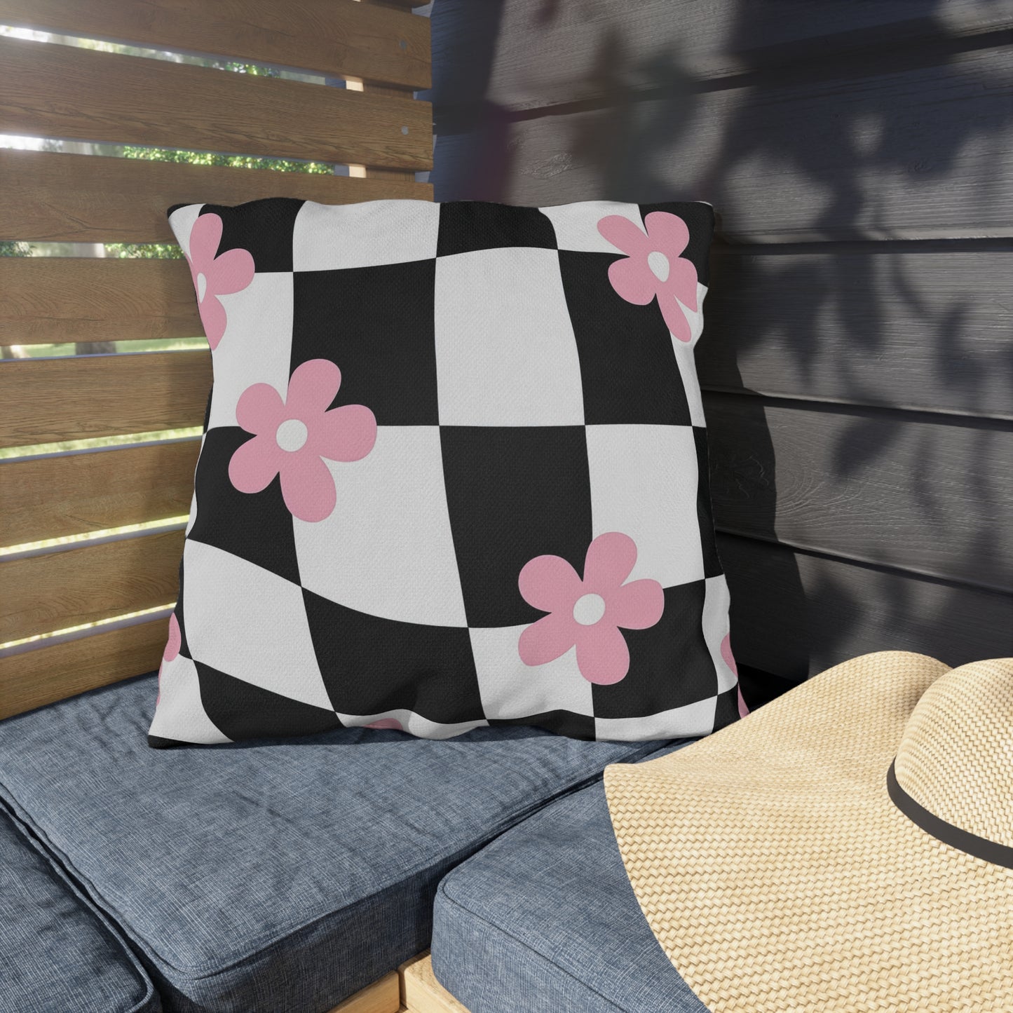 UV- and water-resistant outdoor pillow featuring checkered pattern with pink flowers