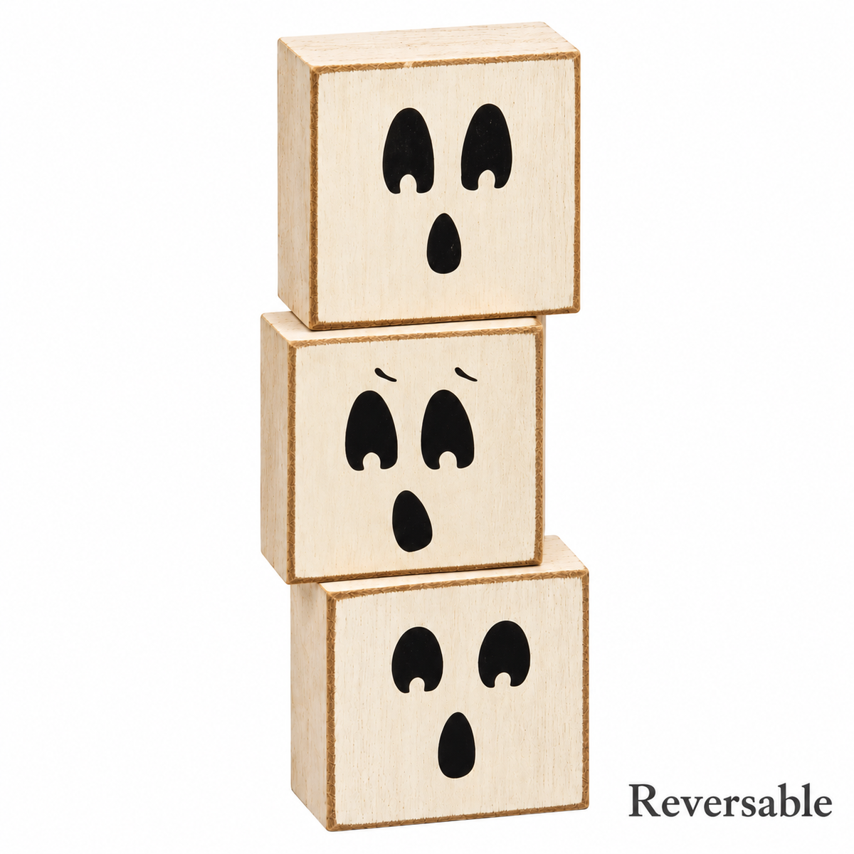 Three stacked wooden toy blocks with black ghost face designs, shown on a white background with the word 'Reversible' in the bottom right corner.