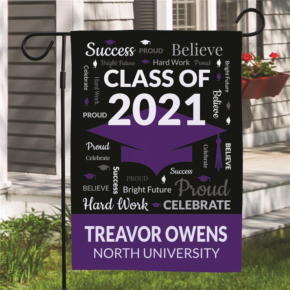 Personalized graduation garden flag with grad cap and year, displayed in a garden bed