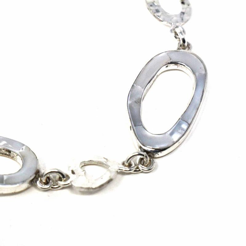 Artisan bracelet featuring natural shell accents and toggle clasp closure
