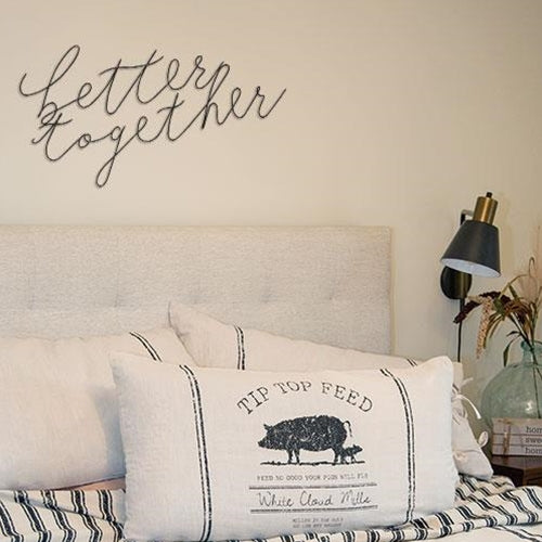 Metal wall decor with script lettering displayed above a couch