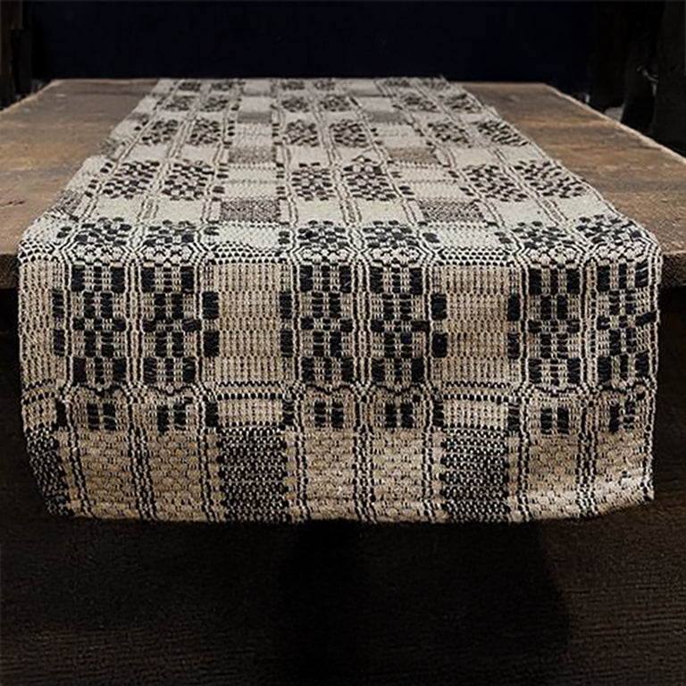 Black and tan checkered woven table runner folded on white surface