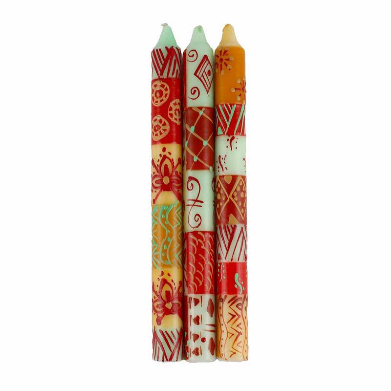 Tall taper candles with natural wicks and brown-toned hand-painted motifs