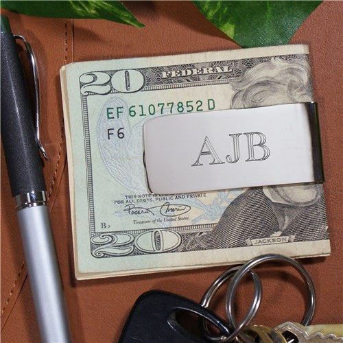 Engraved silver money clip holding folded cash, showcasing its durable, high-luster nickel-plated surface.