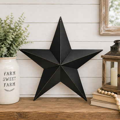Antique black metal barn star with rusty brown detailing and a weathered primitive finish.
