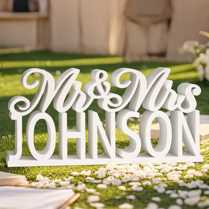 A close-up view of the white 3D printed "Mr. & Mrs." table sign in sunlight, highlighting its clean design and customizable last name option.