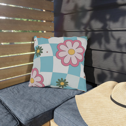 Durable outdoor pillow in blue, pink, and yellow tones against natural background