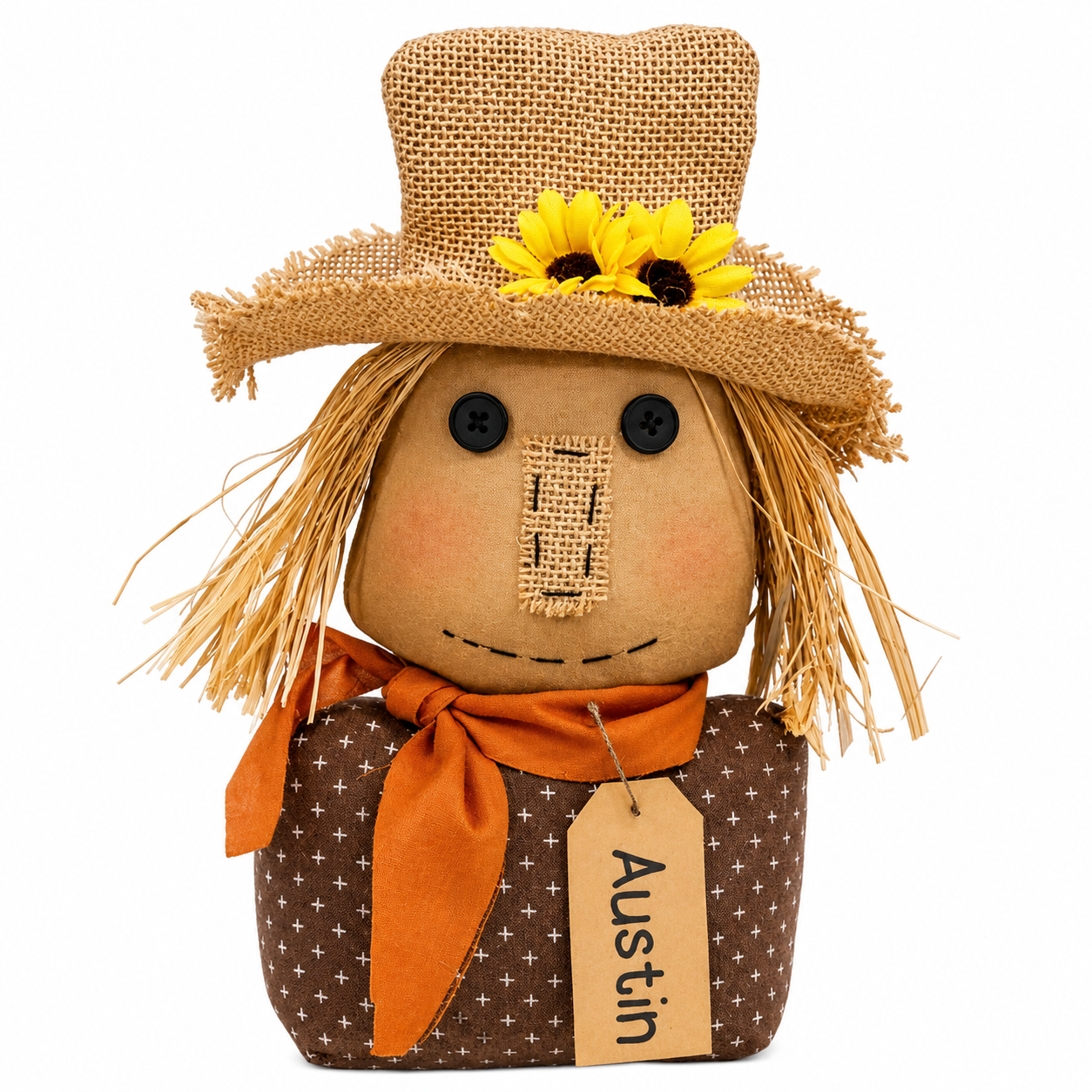 A rustic fabric scarecrow doll with a tan burlap face, straw hair, a woven straw hat with yellow sunflowers, an orange neck scarf, and a brown patterned body. A hanging tag reads 'Austin'.