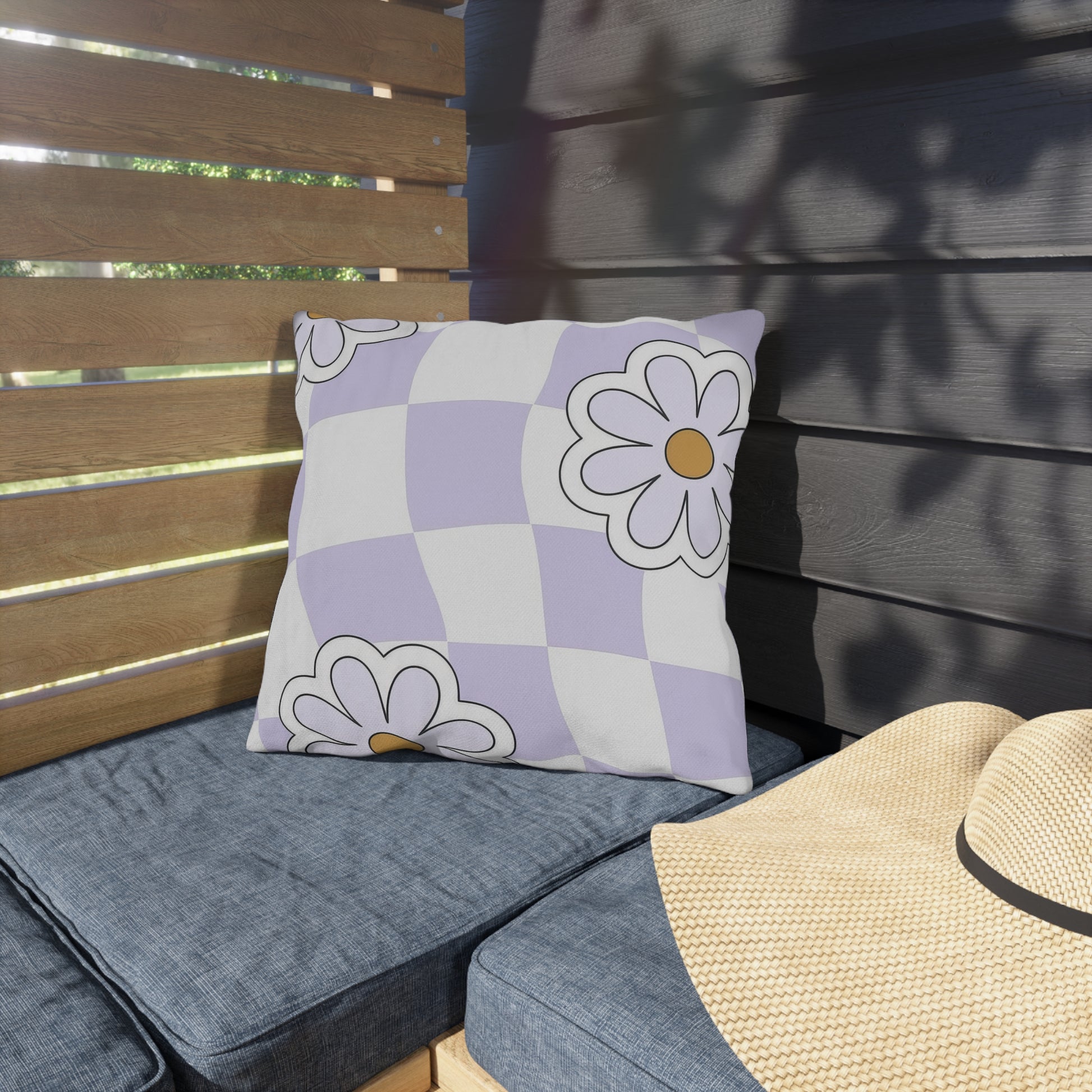 Colorful patio pillow featuring purple and orange flowers on a white checkered background