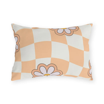 Lumbar pillow with orange daisy design in cream and black on patio chair