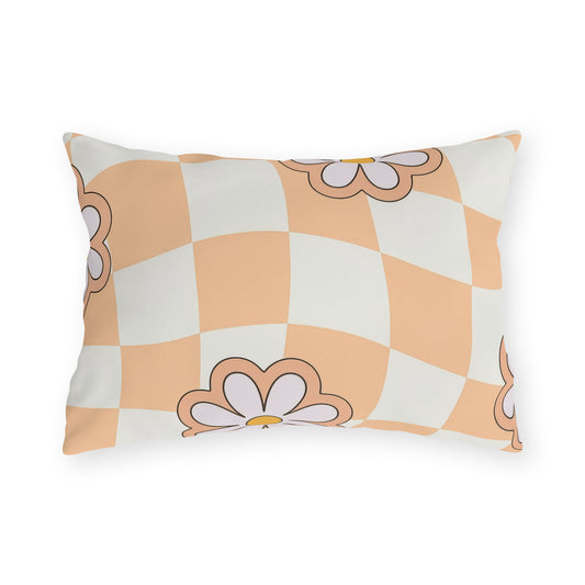 Lumbar pillow with orange daisy design in cream and black on patio chair