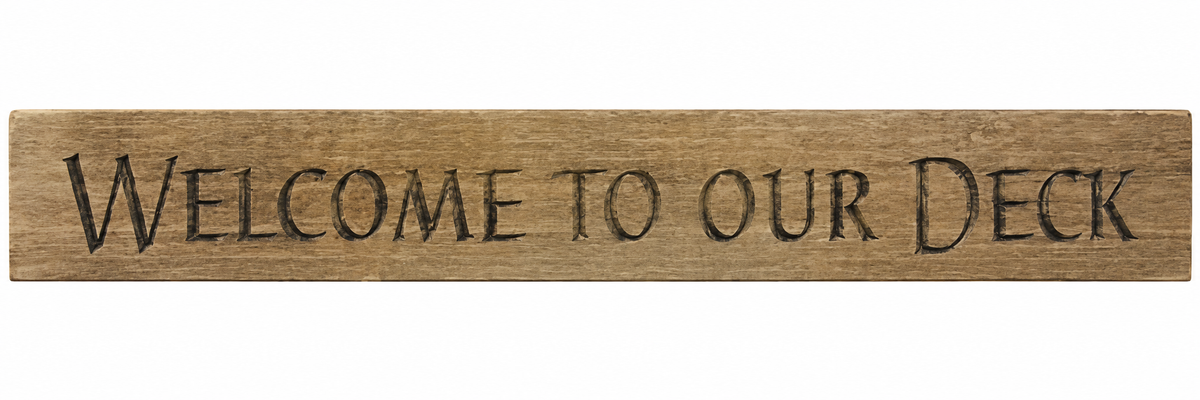 A rectangular rustic wooden sign with the phrase 'WELCOME TO OUR DECK' carved or printed in dark lettering, shown against a plain white background.