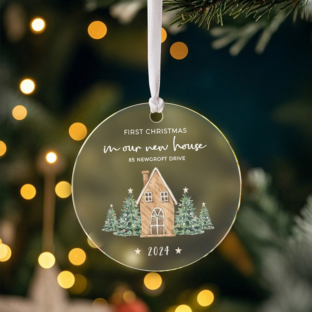 A front view of the personalized Christmas ornament featuring a house surrounded by Christmas trees with the text "First Christmas in our new home," ready to be customized with the address and year.