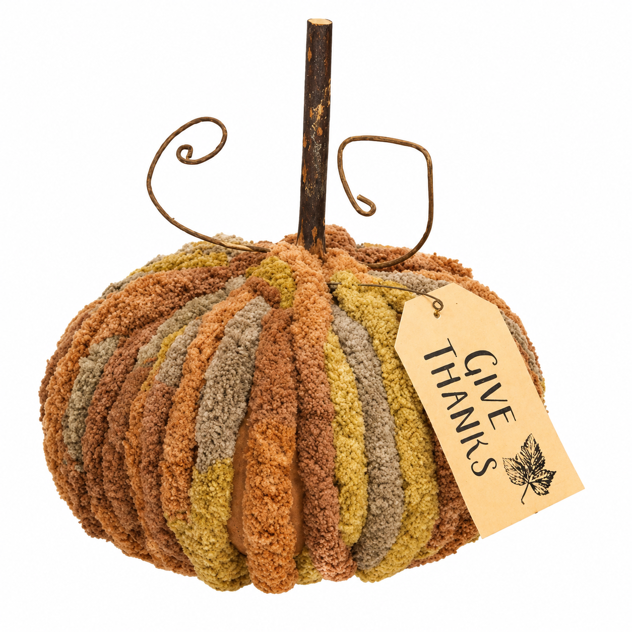 A decorative autumn pumpkin decoration made from textured vertical yarn-like strips in rust, tan, ochre, and muted gray-brown, with a rustic dark stem and curled wire details. A paper tag hangs from the stem and reads “GIVE THANKS” with a small leaf graphic, photographed on a plain white background.