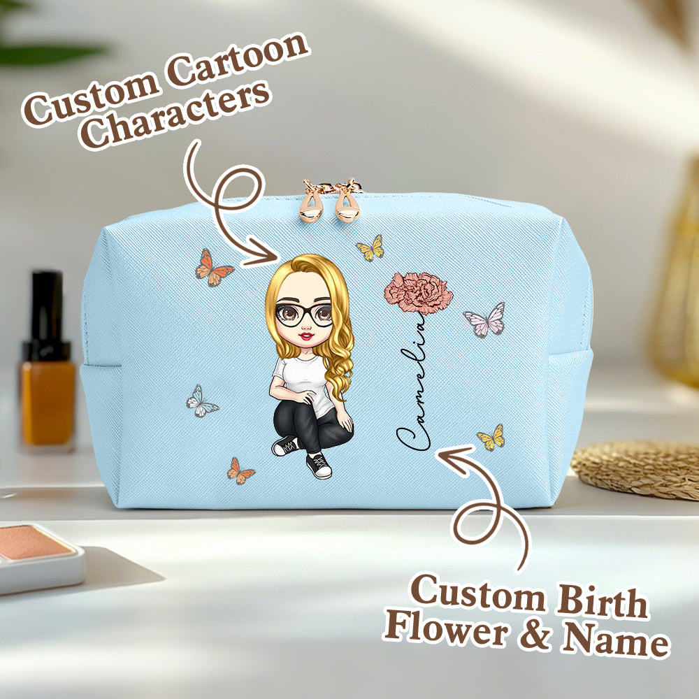 A blue personalized makeup bag on a table, featuring a custom cartoon character, birth flower, and name, with an overlay saying custom cartoon characters and custom birth flower and name.