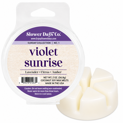 Slower Days Co. 'Violet Sunrise' coconut soy wax melts in a clear plastic clamshell package with a white and purple label, shown next to three cream-colored wax melts.