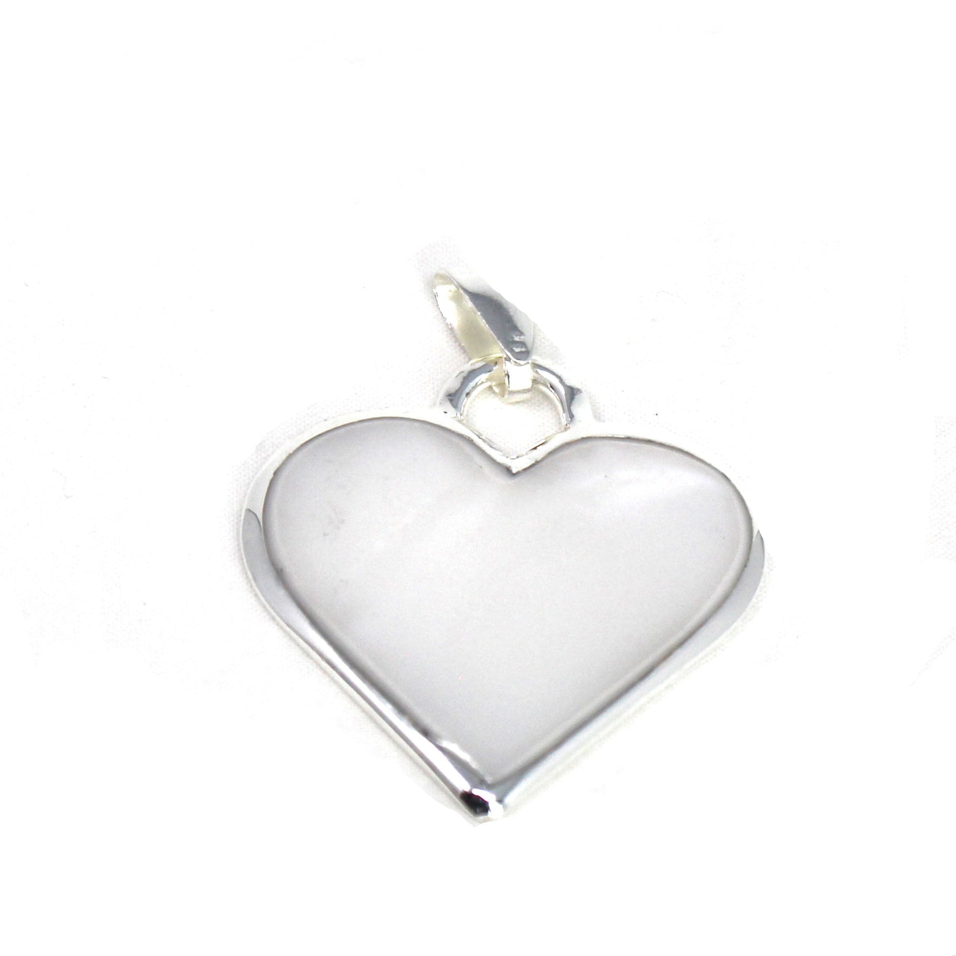 Corazón Blanco heart pendant resting on rustic wood background