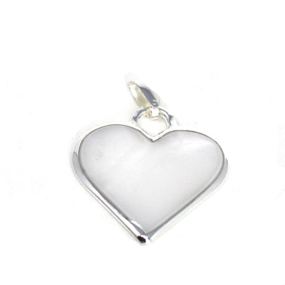 Corazón Blanco heart pendant resting on rustic wood background
