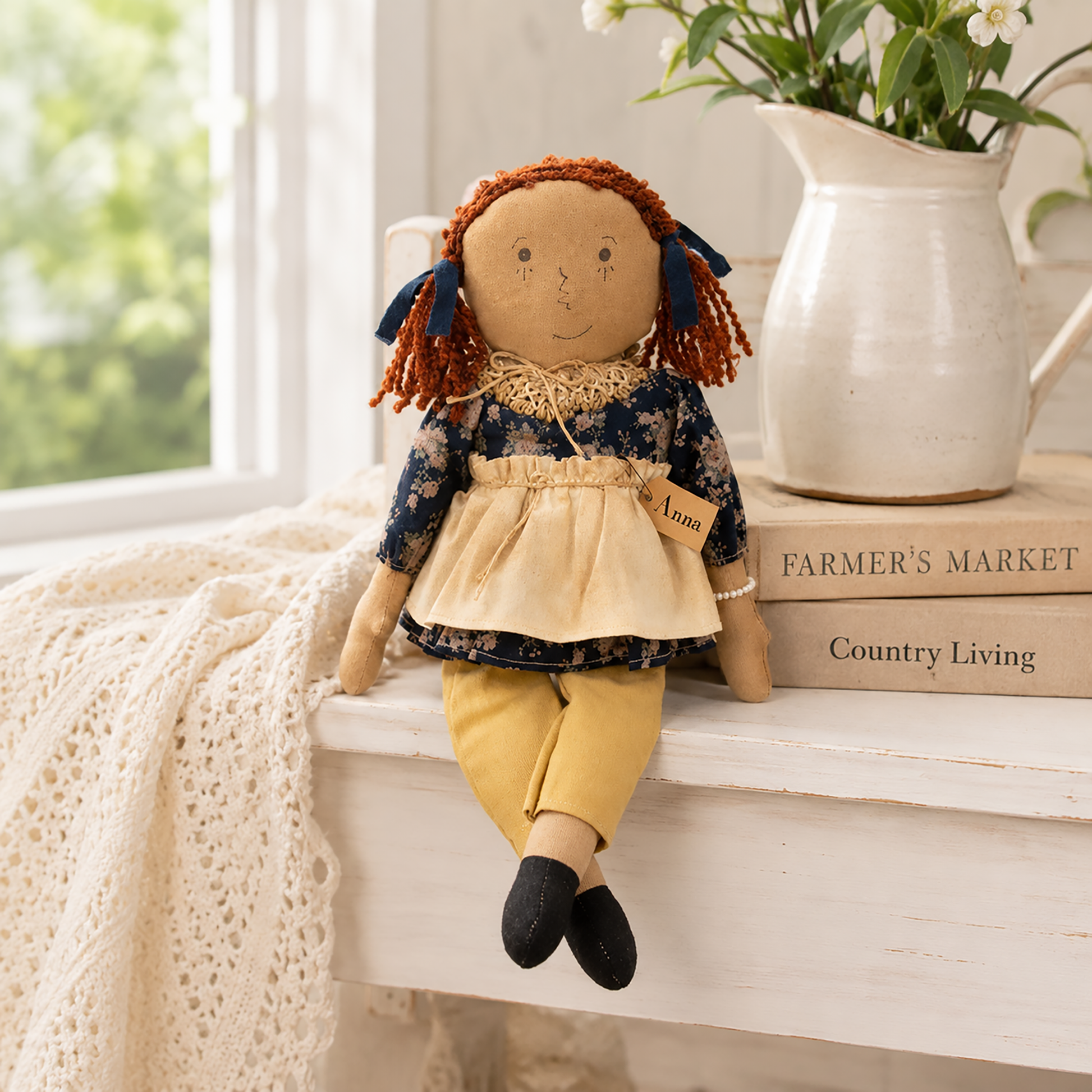 Anna primitive rag doll shelf sitter wearing a navy floral top, cream apron, tan pants, and black shoes with dangling legs for farmhouse home décor.