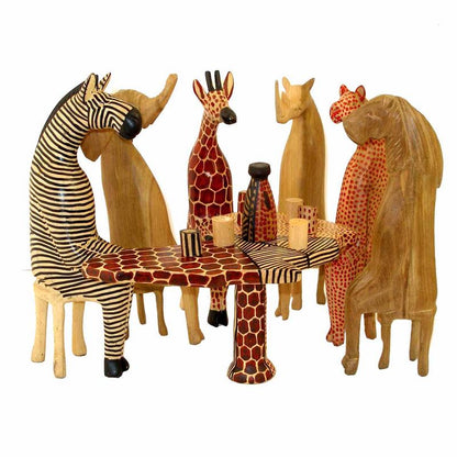 Hand-carved wooden animal set featuring six animals sitting around a carved table, crafted by artisans in Kenya.