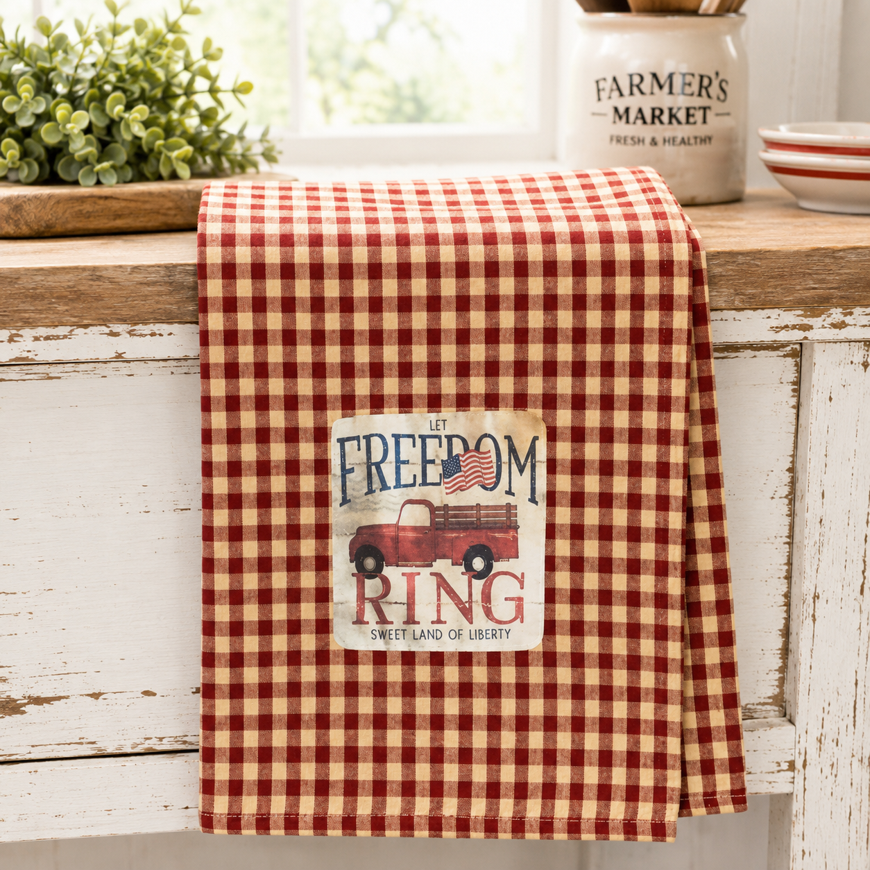 Patriotic cotton dish towel featuring a vintage red truck, Let Freedom Ring artwork, and red and white gingham design for farmhouse kitchen decor