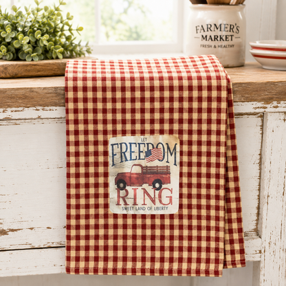 Patriotic cotton dish towel featuring a vintage red truck, Let Freedom Ring artwork, and red and white gingham design for farmhouse kitchen decor