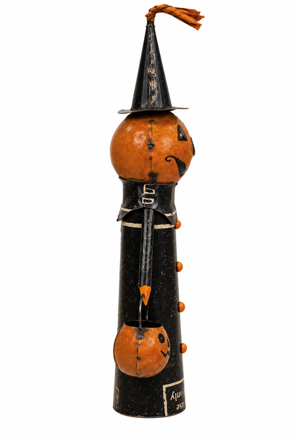 A handcrafted Halloween decoration shaped like a figure wearing a witch hat and black clothing, with orange gourd accents and carved jack-o'-lantern faces, photographed on a plain white background.