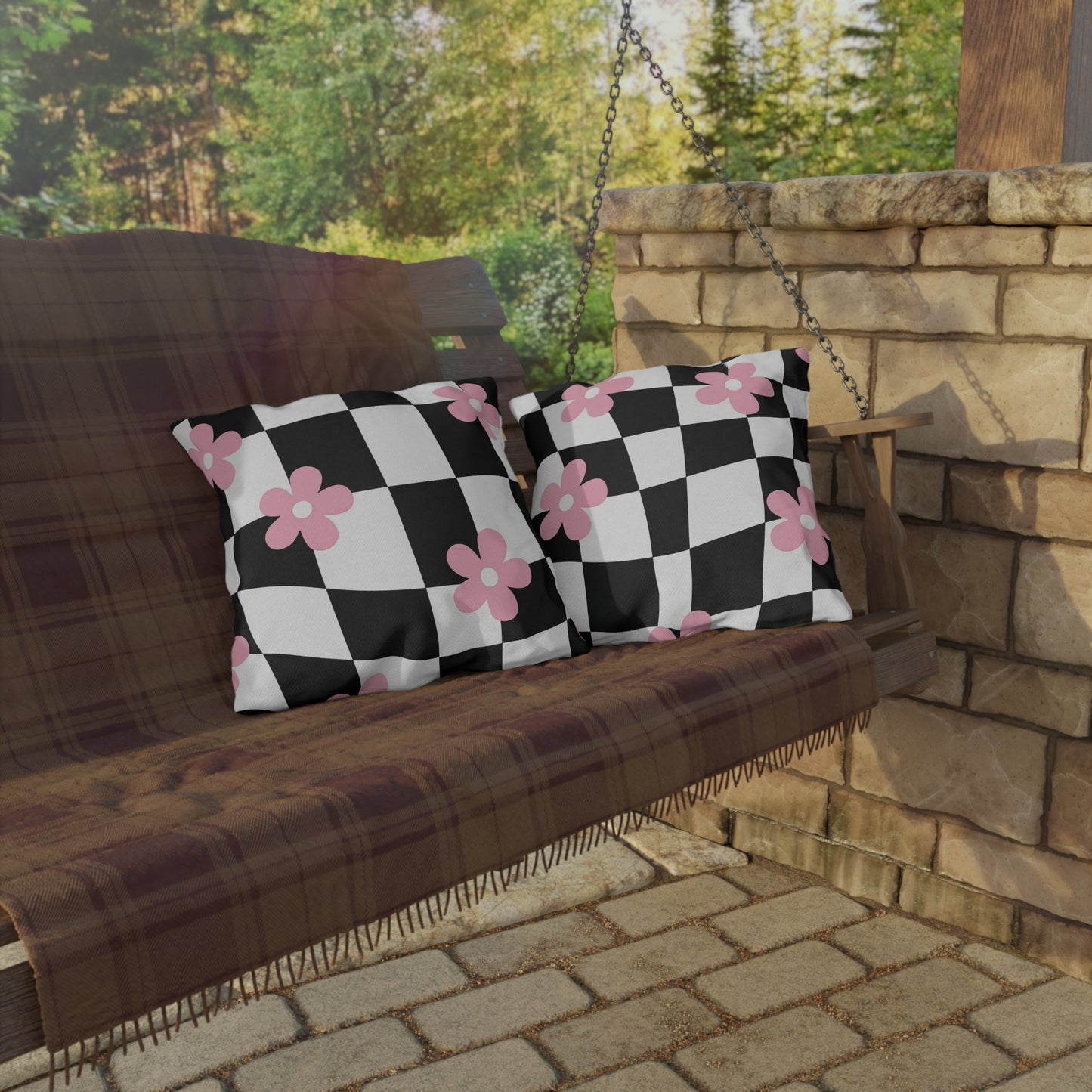 Weather-resistant cushion with bold check pattern and floral overlay on outdoor chair