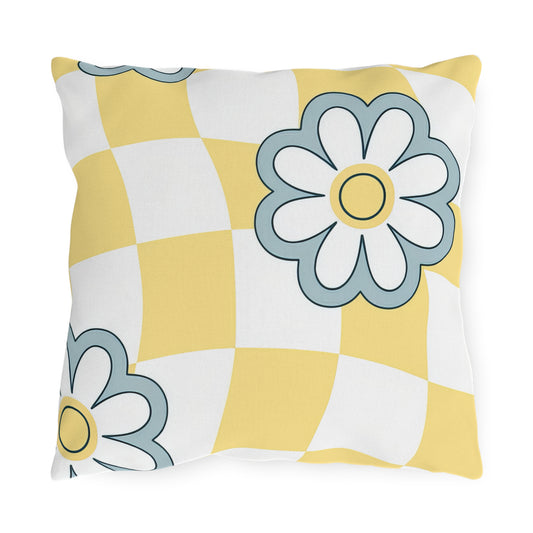 Square outdoor pillow with yellow checkered pattern and blue floral accents on patio furniture