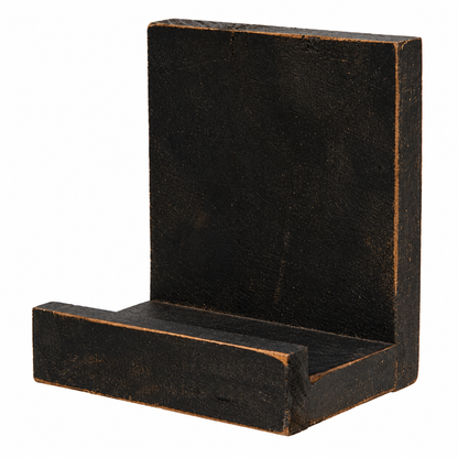 A rustic black painted wooden L-shaped bracket or shelf support with a distressed finish showing warm brown wood undertones, isolated on a white background.