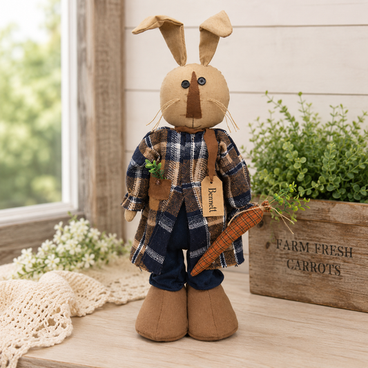 Primitive bunny figure named Bennett wearing a navy and orange plaid coat, navy pants, and light brown shoes while holding a stuffed plaid carrot, displayed as rustic spring farmhouse and Easter home décor.