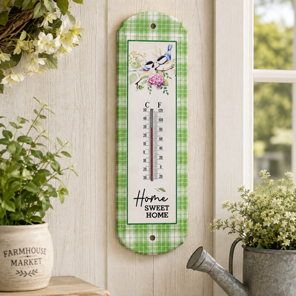 Home Sweet Home metal wall thermometer with watercolor birds on flowering branches, green plaid border, and Fahrenheit and Celsius readings.