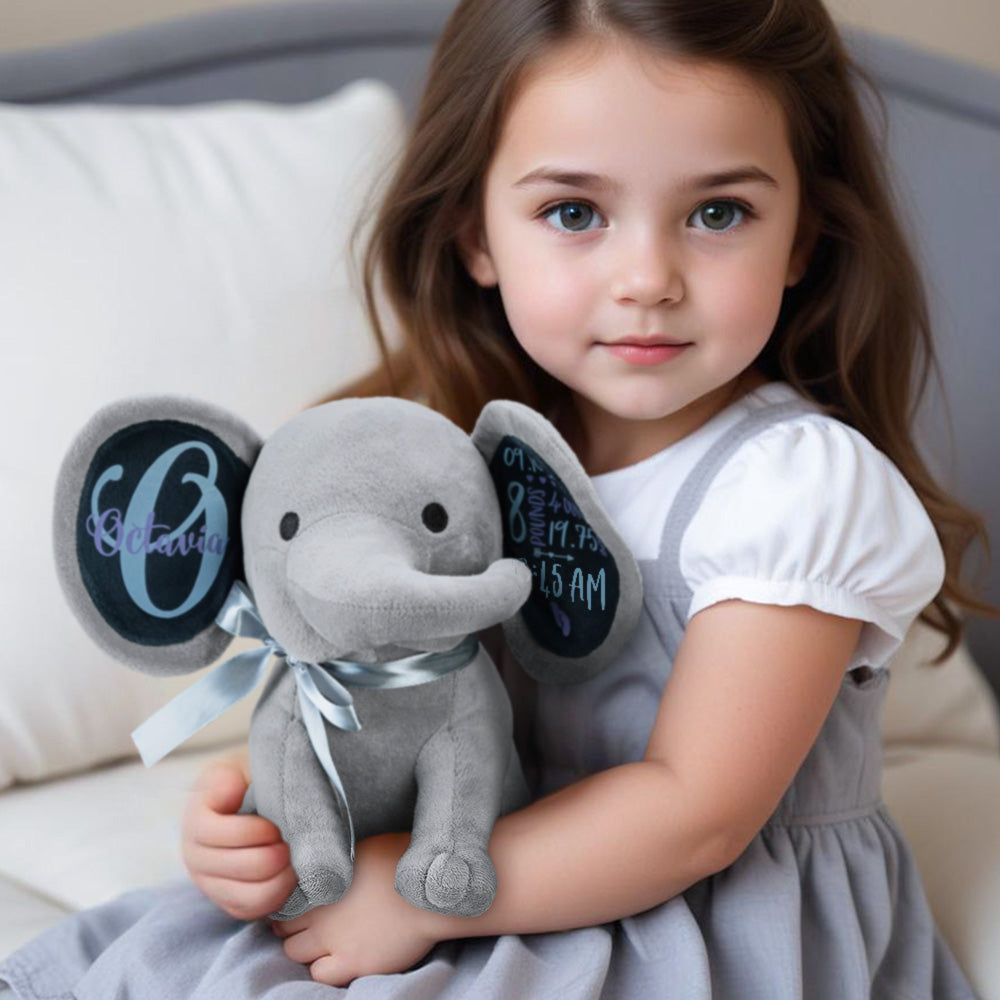 A little girl holding a stuffed elephant toy, showcasing the personalized custom name on the toy.