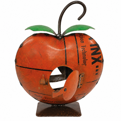 A vintage-style metal apple-shaped bird feeder or decorative sculpture with a rusted orange finish, black printed text, green leaves, a curved metal stem, and a small hinged door on a stand.