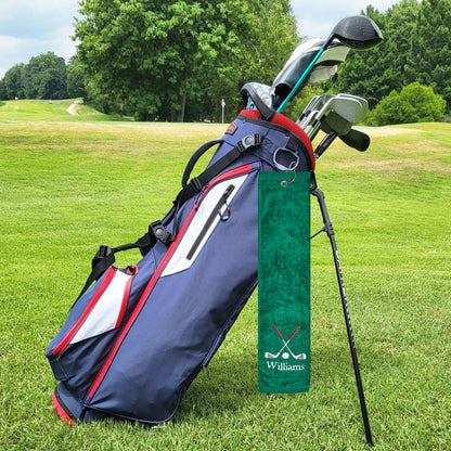 A green golf towel with the customer's personalized embroidered last name, attached to a golf bag with a sturdy clip for easy access.