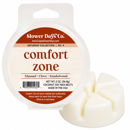 A round plastic tub of Slower Days Co. comfort zone wax melts next to three unwrapped off-white wax melts on a white background.