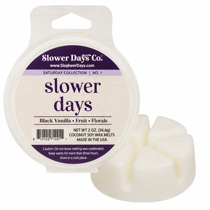 Slower Days Co. Coconut soy wax melts in a round clear plastic tub with a white plastic lid and a small sample of the off-white wax melts shown beside it.
