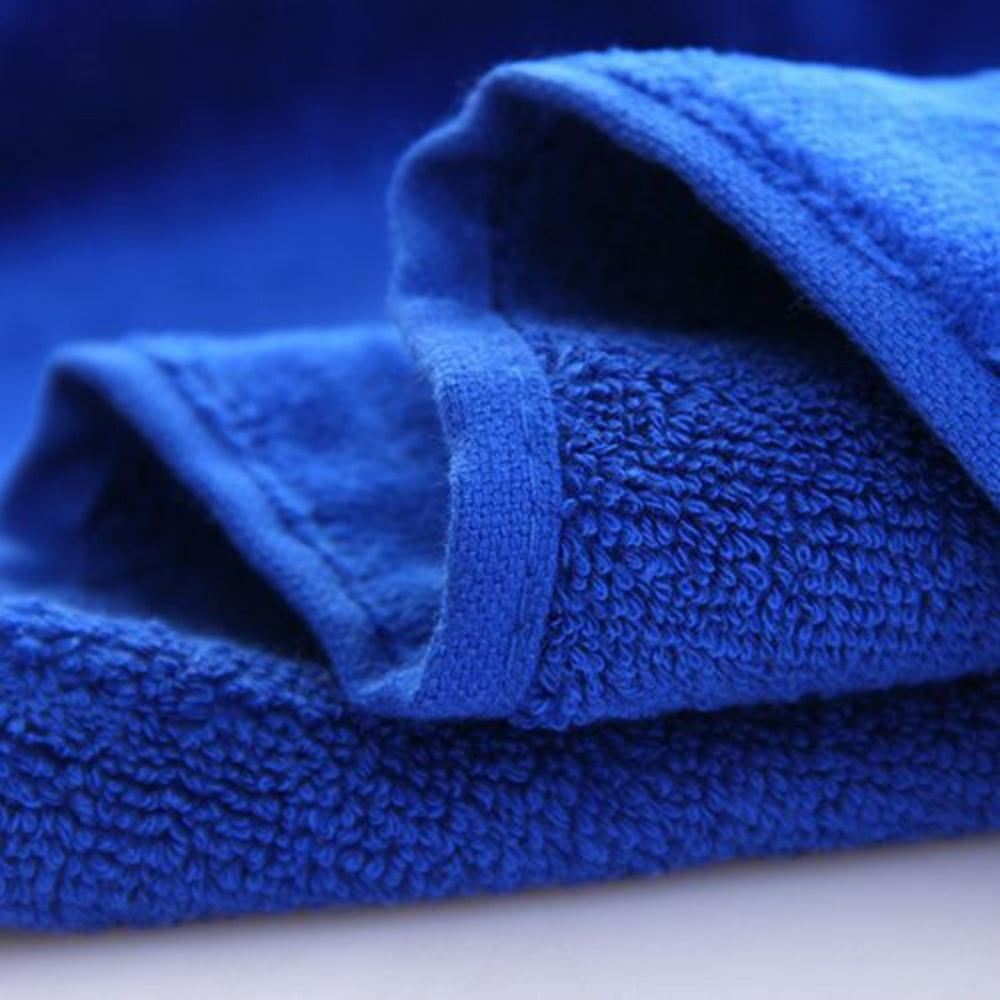 A super close-up view of a blue golf towel, highlighting the soft, absorbent fabric and the personalized embroidered last name.