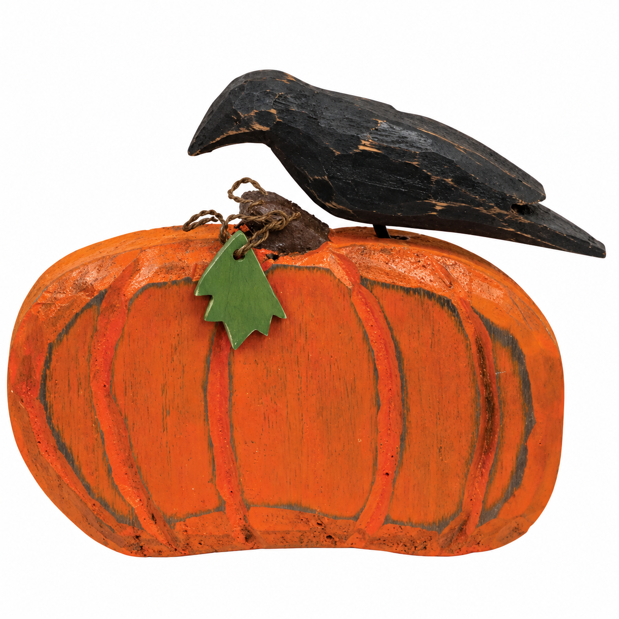 Handcrafted folk art decorative sculpture of a black bird perched on an orange pumpkin, featuring a small green leaf accent, isolated on a white background.