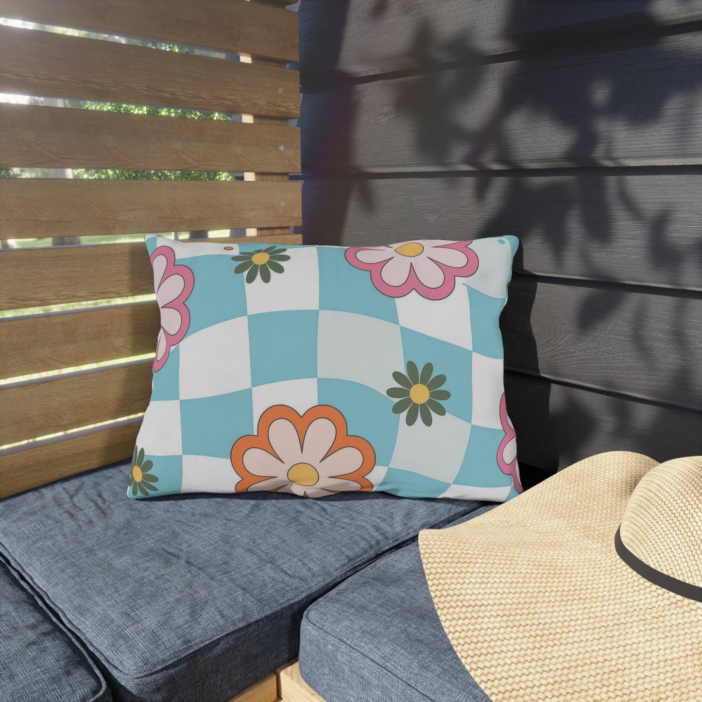 Double-sided floral lumbar pillow placed on wooden outdoor seating
