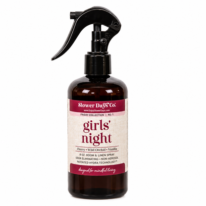An 8 oz room and linen spray bottle from Blower Days Co. featuring a dark amber brown bottle, a black trigger spray top, and a cream label with burgundy text reading 'girls' night'.