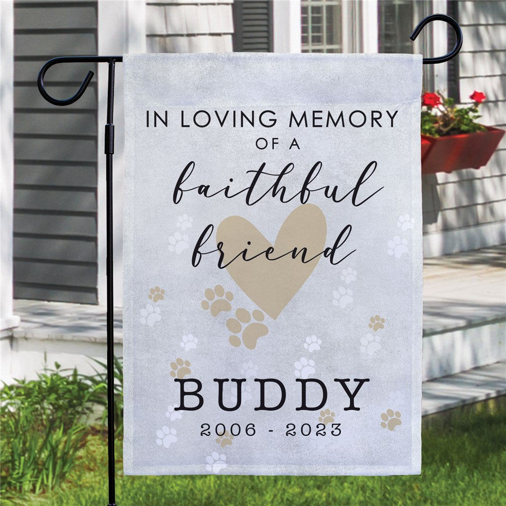 Pet memorial garden flag with personalized name and years, displayed outdoors in a garden setting
