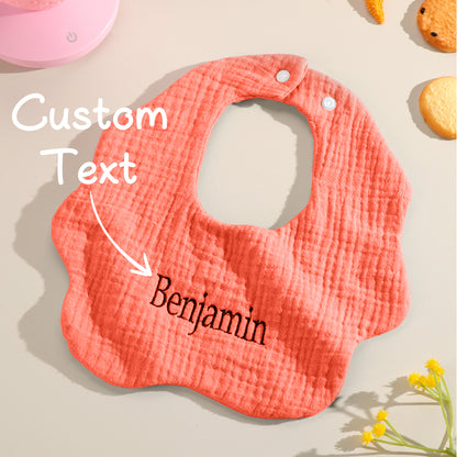 Orange baby bib with customizable text overlay, offering a unique gift option. Personalize with a name for a special baby shower or welcome gift.