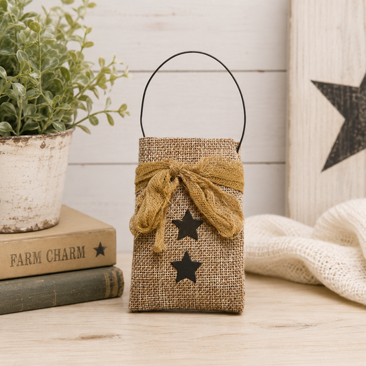 Small primitive burlap hanging bag with black star design, tea-dyed cheesecloth ribbon, and black wire hanger for farmhouse decor
